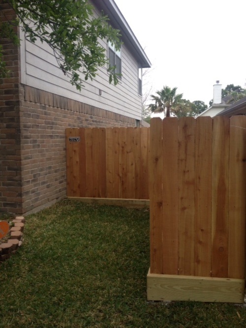 wood fence at the side of a house in the woodlands