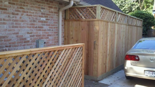 wood fence on the side of a home in the woodlands